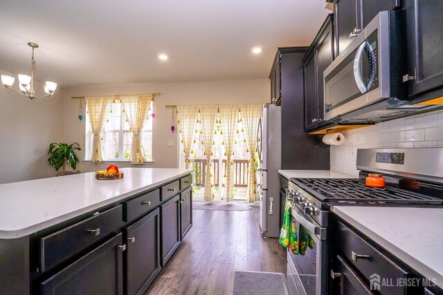 102 Matutina Rd, Monroe, NJ 08831 - kitchen featuring appliances with stainless steel finishes, decorative backsplash, dark wood finished floors, a chandelier, and pendant lighting