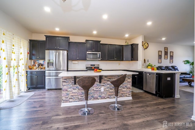 102 Matutina Rd, Monroe, NJ 08831 - kitchen featuring appliances with stainless steel finishes, light countertops, decorative backsplash, a kitchen bar, and a peninsula