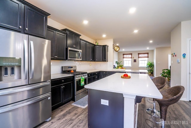 102 Matutina Rd, Monroe, NJ 08831 - kitchen with appliances with stainless steel finishes, a kitchen bar, dark wood-type flooring, a center island, and recessed lighting