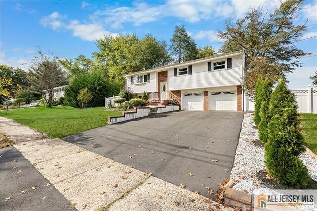 bi-level home featuring a garage and a front lawn