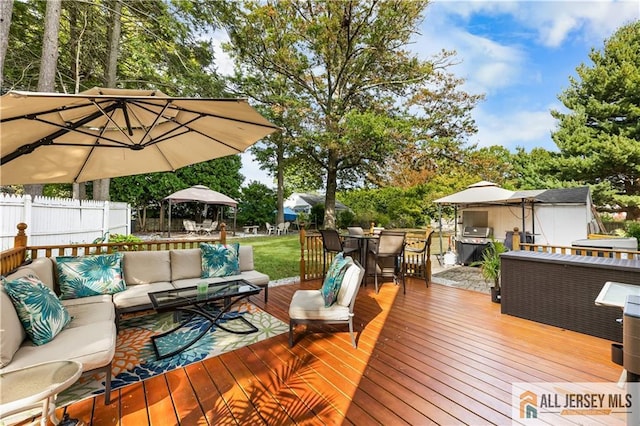 wooden terrace with grilling area, a gazebo, and an outdoor hangout area