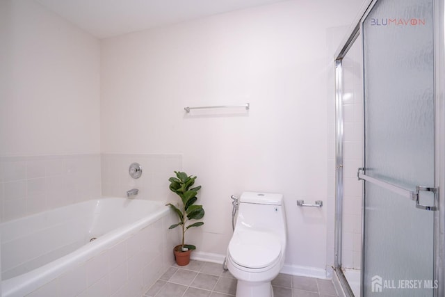 bathroom featuring toilet, tile patterned flooring, and shower with separate bathtub