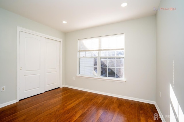 unfurnished bedroom featuring a closet and hardwood / wood-style floors