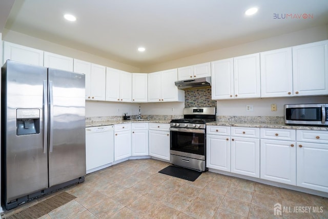 kitchen featuring white cabinets, appliances with stainless steel finishes, tasteful backsplash, sink, and light stone counters