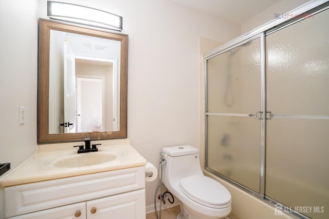 full bathroom with toilet, combined bath / shower with glass door, and vanity