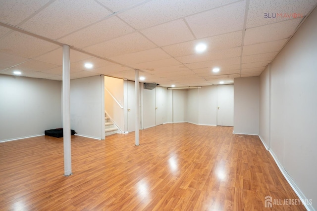 basement featuring hardwood / wood-style floors and a paneled ceiling