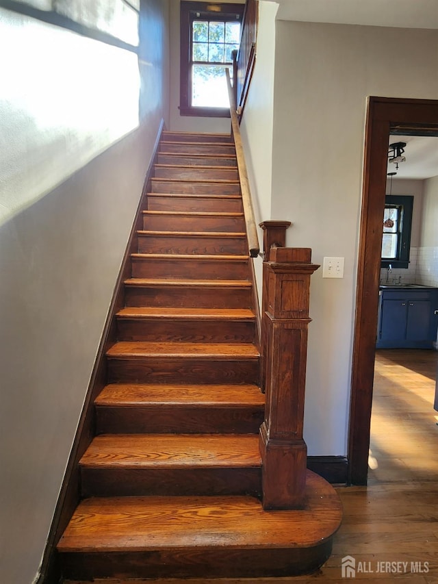 stairs featuring hardwood / wood-style floors