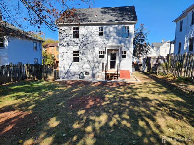 back of house with a lawn