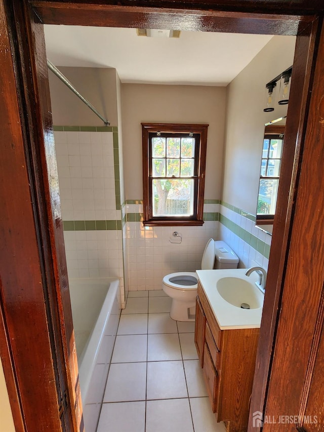 bathroom featuring tile patterned flooring, vanity, tile walls, and toilet