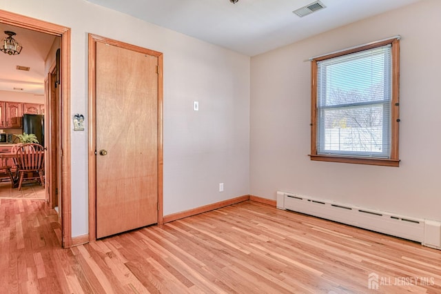 19 W Joffre Ave W, Milltown, NJ 08850 - unfurnished bedroom with a baseboard heating unit, light wood-style floors, and freestanding refrigerator