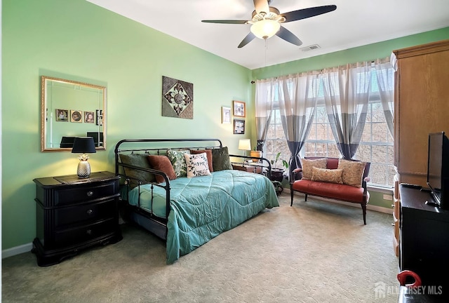 carpeted bedroom with visible vents, baseboards, and a ceiling fan