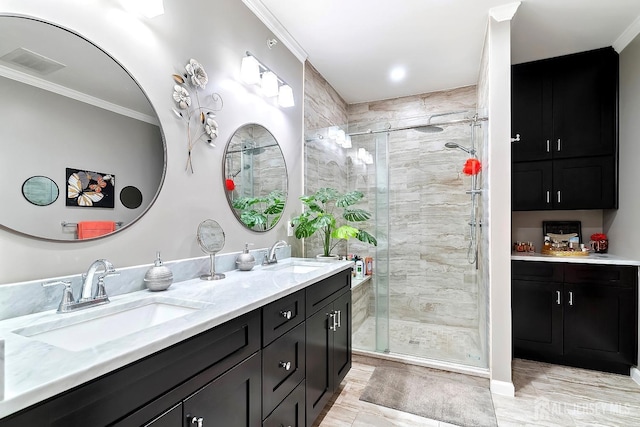 bathroom featuring a sink, visible vents, a stall shower, and ornamental molding