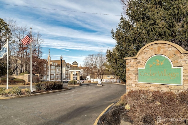 view of road with a gated entry, curbs, and street lights