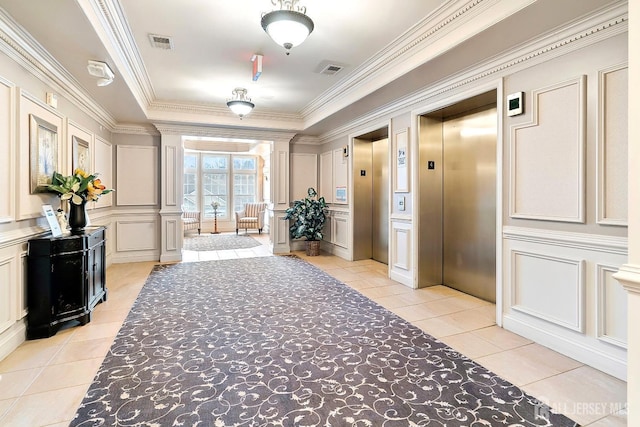 hall featuring visible vents, elevator, crown molding, a decorative wall, and light tile patterned floors