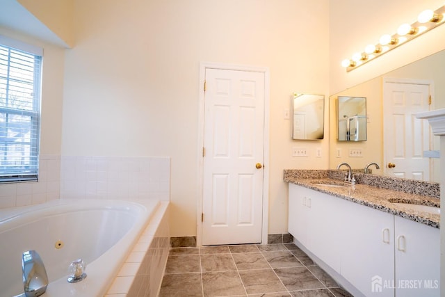 bathroom with tile patterned floors, vanity, and tiled tub