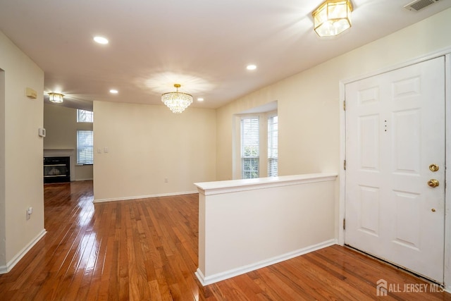 entryway with an inviting chandelier, plenty of natural light, and hardwood / wood-style floors