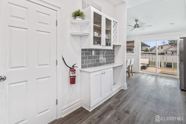 94 2nd St, Keyport, NJ 07735 - kitchen featuring white cabinetry, glass insert cabinets, light countertops, dark wood-type flooring, and decorative backsplash
