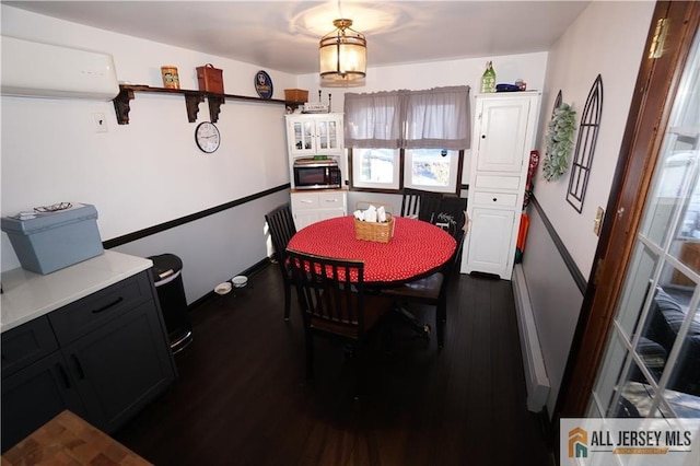 dining space with dark wood-style floors, a wall unit AC, and baseboards