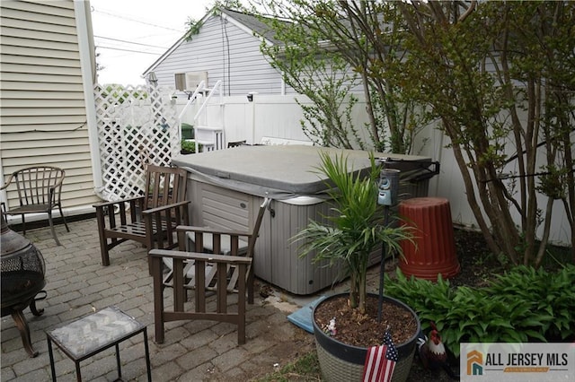 view of patio featuring a hot tub and fence