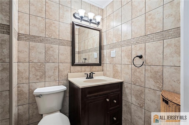 bathroom with tile walls, vanity, and toilet