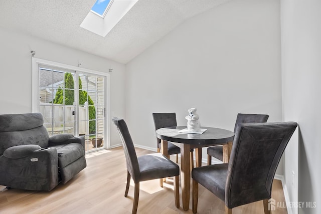 334 Waterside Blvd, Monroe, NJ 08831 - dining room featuring a skylight, lofted ceiling, light wood-style flooring, and a textured ceiling