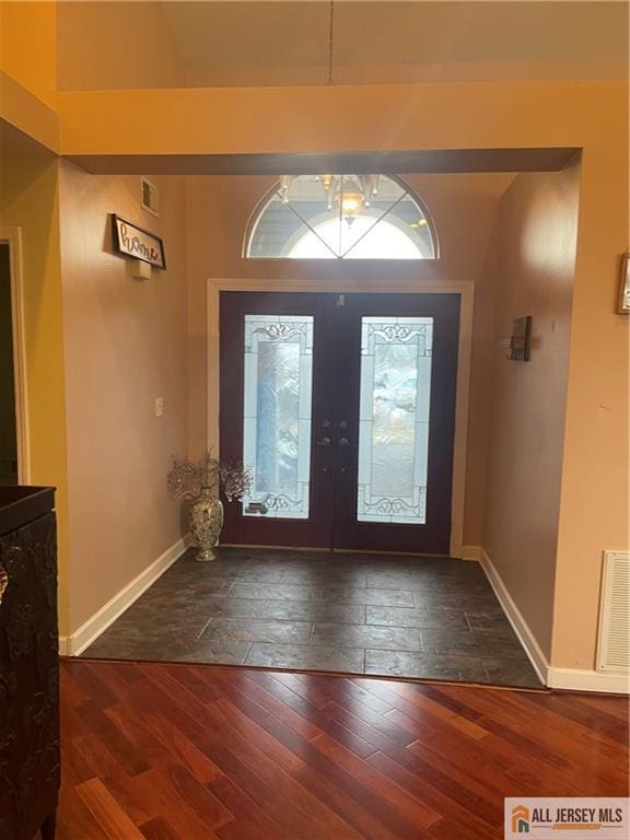 foyer entrance with dark wood-style floors, french doors, visible vents, and baseboards