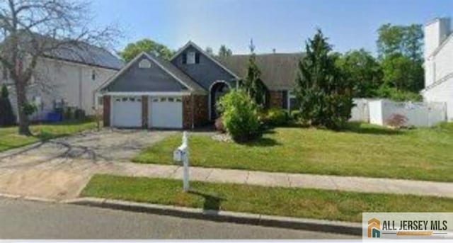 ranch-style home featuring a front lawn, driveway, and an attached garage