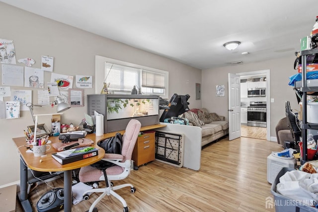 home office featuring electric panel and light wood-type flooring