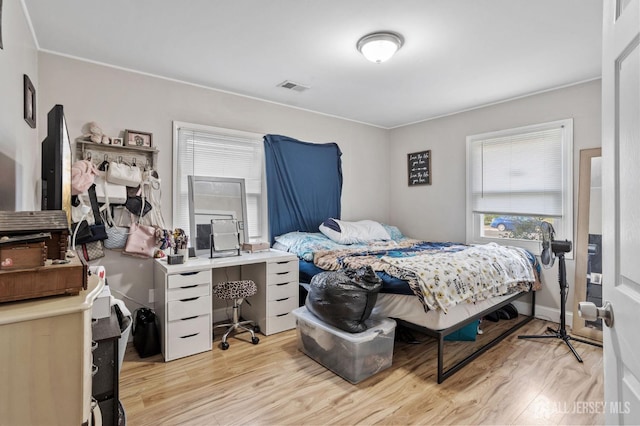 bedroom featuring wood finished floors and visible vents