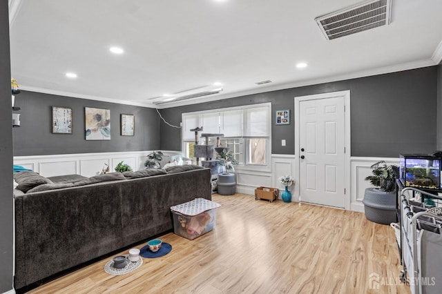living area featuring visible vents, a wainscoted wall, recessed lighting, ornamental molding, and wood finished floors