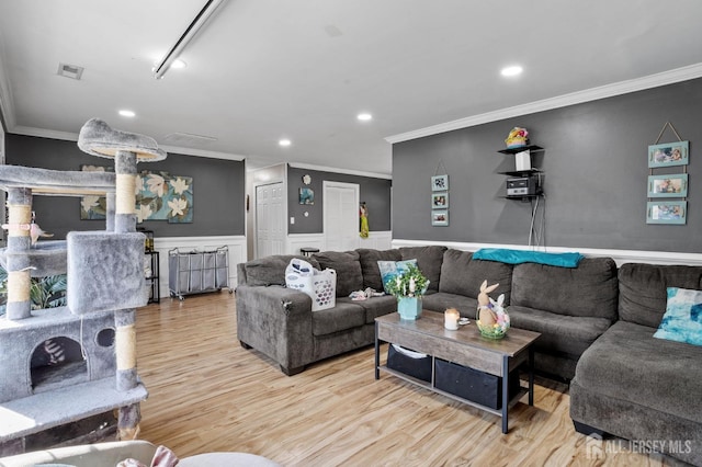 living room with wood finished floors, crown molding, recessed lighting, and wainscoting