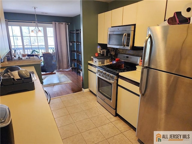 6232 Cedar Ct, South Brunswick, NJ 08852 - kitchen with appliances with stainless steel finishes, light tile patterned flooring, tasteful backsplash, light countertops, and white cabinets