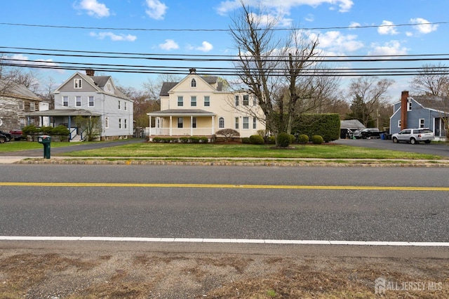 view of front of home with a residential view and a front lawn
