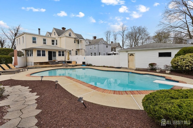 view of swimming pool with fence, a patio area, entry steps, a fenced in pool, and a diving board