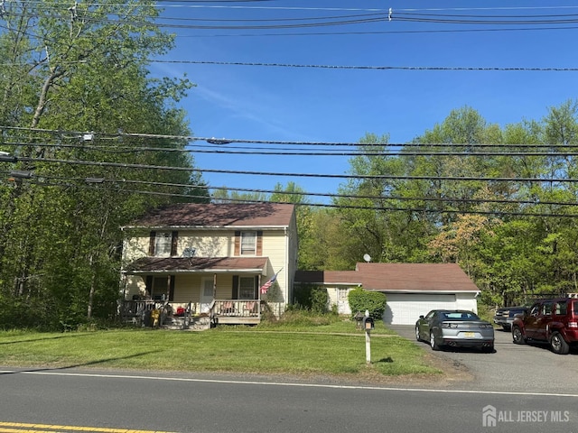 colonial inspired home with a garage, covered porch, and a front lawn