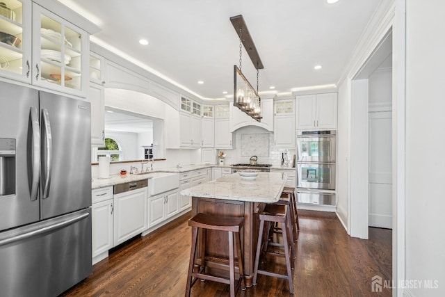 59 S Main St, Cranbury, NJ 08512 - kitchen featuring appliances with stainless steel finishes, a center island, tasteful backsplash, a warming drawer, and white cabinets