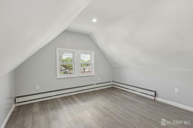 additional living space featuring wood finished floors, lofted ceiling, baseboard heating, baseboards, and recessed lighting