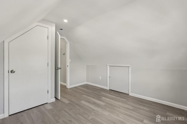 bonus room with vaulted ceiling, wood finished floors, and baseboards