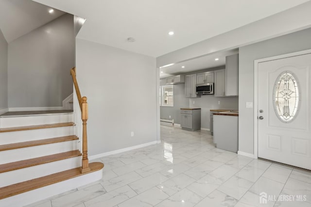 entrance foyer featuring light marble finish flooring, recessed lighting, stairs, baseboards, and a wall mounted air conditioner