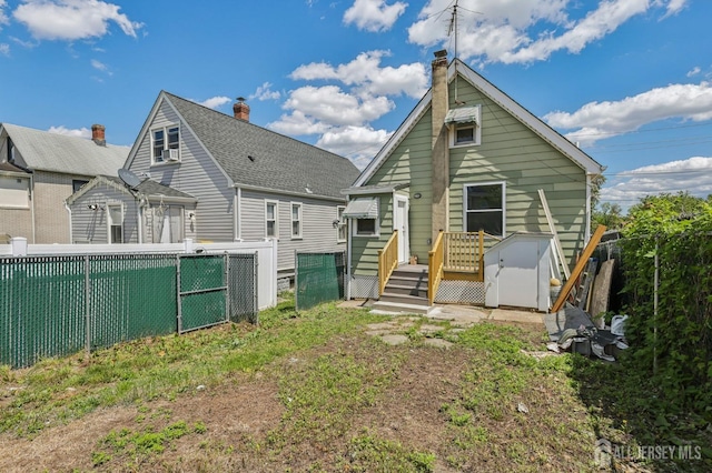 rear view of property featuring a fenced backyard and a deck