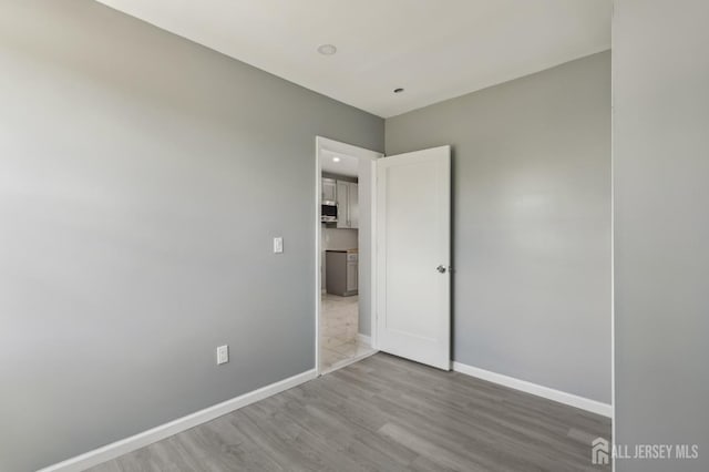 unfurnished bedroom with wood finished floors and baseboards