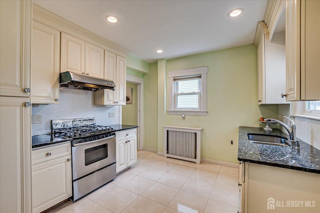 311 Prospect Ave, Dunellen, NJ 08812 - kitchen with under cabinet range hood, gas stove, radiator, tasteful backsplash, and dark stone counters