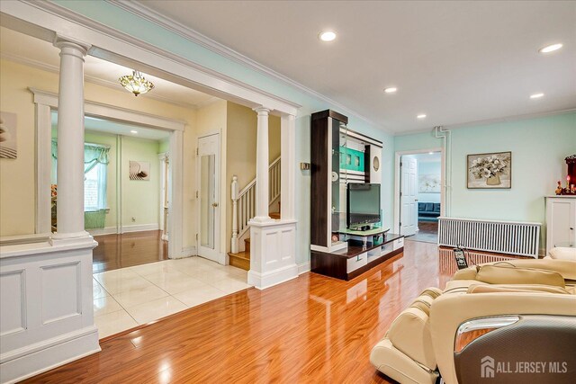 311 Prospect Ave, Dunellen, NJ 08812 - living room featuring crown molding, decorative columns, recessed lighting, light wood finished floors, and stairway