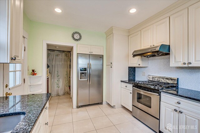 311 Prospect Ave, Dunellen, NJ 08812 - kitchen with appliances with stainless steel finishes, under cabinet range hood, light tile patterned floors, dark stone countertops, and decorative backsplash