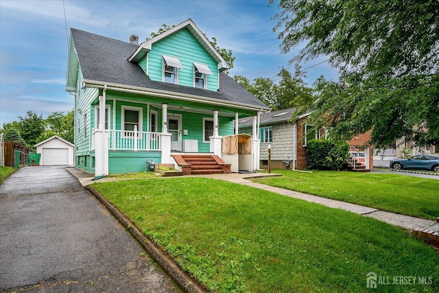 311 Prospect Ave, Dunellen, NJ 08812 - bungalow featuring covered porch, an outbuilding, a garage, asphalt driveway, and a front lawn