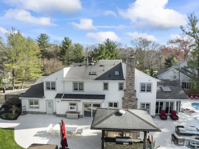 7 Leighton Dr, East Brunswick, NJ 08816 - back of property featuring outdoor lounge area, a patio, a chimney, and a jacuzzi