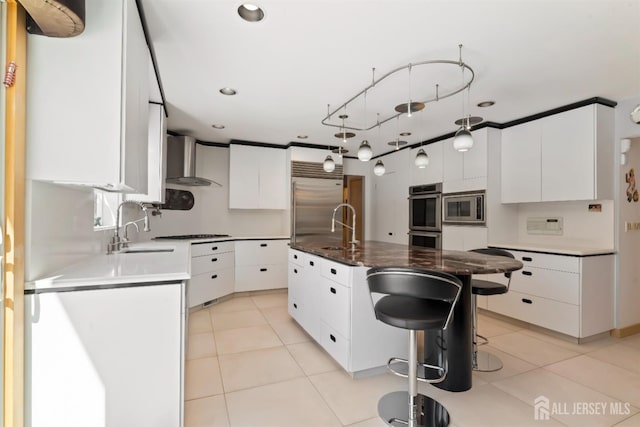 7 Leighton Dr, East Brunswick, NJ 08816 - kitchen featuring built in appliances, wall chimney exhaust hood, white cabinetry, and a sink
