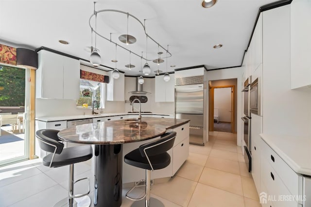 7 Leighton Dr, East Brunswick, NJ 08816 - kitchen featuring white cabinets, built in refrigerator, pendant lighting, and a kitchen breakfast bar