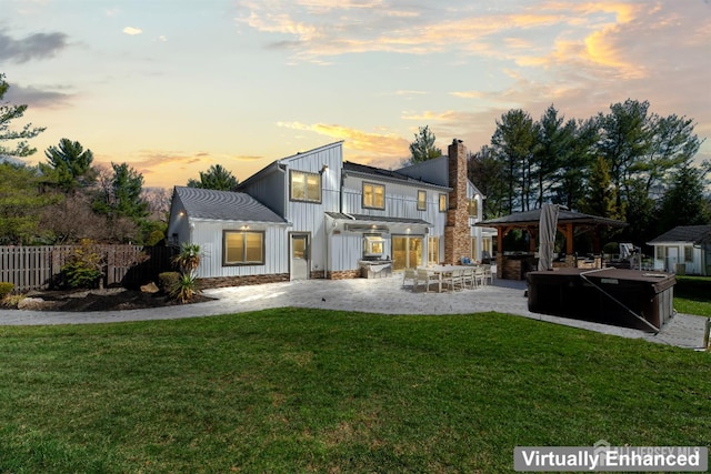 7 Leighton Dr, East Brunswick, NJ 08816 - back of property at dusk with a gazebo, a chimney, fence, a lawn, and board and batten siding