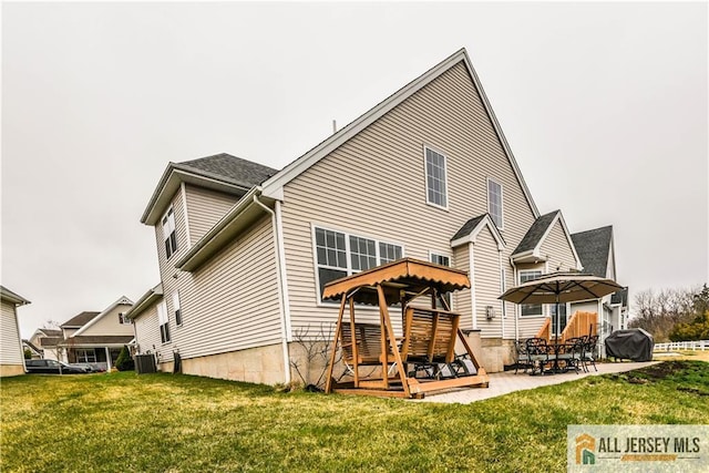 back of property with a lawn, a patio area, and central AC